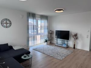 a living room with a couch and a flat screen tv at Ferienwohnung Dariana Schwalbach/Saar in Schwalbach