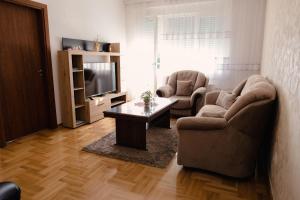 a living room with two chairs and a table and a television at Lux 010 in Pirot