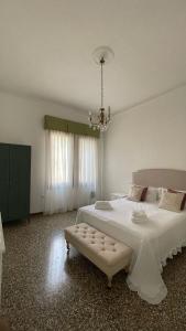 a bedroom with a large white bed and a chandelier at Residenza Stardust Suite with Canal View in Venice