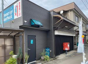 un edificio con una porta blu e un telefono pubblico di 恐竜博物館まで車で5分 自然体験 古来農業体験ができる一棟貸し宿Dinosaur Agri a Katsuyama