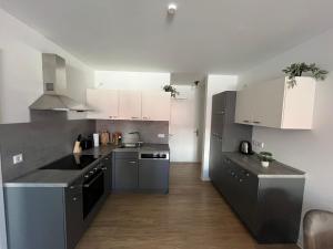 a kitchen with gray counters and white cabinets at Wohnglück Leer-Altstadt in Leer