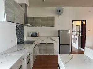 una cucina con ripiani bianchi e frigorifero di Sunshine House By Serenity Sea House a Ban Khao Khwang (2)