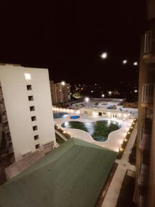 a view of a building with a swimming pool at night at Apartamento Vacacional con Piscina WiFi y Netflix a 20 min del Parque Tayrona ideal para trabajo remoto in Santa Marta