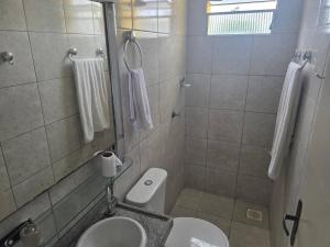 a bathroom with a white toilet and a sink at Tesouro da Maraponga in Fortaleza +11 photos