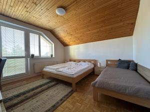 a bedroom with two beds and a wooden ceiling at Relax Villa Tatry - Wifi/TV, BBQ, Billiard in Nová Lesná