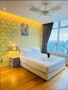 a bedroom with a large bed with a yellow wall at Vortex Premium Apartment klcc in Kuala Lumpur +18 photos