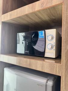 a tv sitting on a shelf next to a printer at Maya Residence in Pattaya South