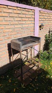 a bench sitting in front of a brick wall at Departamentos Turísticos Saavedra in El Bolsón