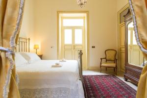 een slaapkamer met een bed, een stoel en een raam bij B&B Porta Carolina in Palermo