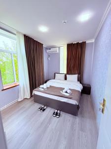 a bedroom with a bed and a large window at Elit Hostel Qabala in Gabala
