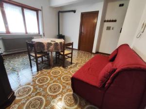 a living room with a red couch and a table at Appartamento l'ara in Scanno