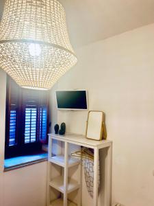 a room with a desk and a large chandelier at La casa di Nemi in Trapani