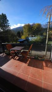 una mesa de picnic y un banco en un patio en Departamentos Turísticos Saavedra, en El Bolsón
