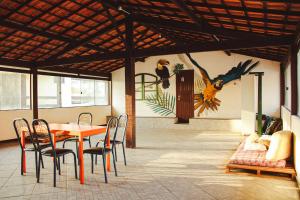 a dining room with a table and chairs and a mural at A Bella Foguete, Beach Hostel & Suites, Cabo Frio in Cabo Frio