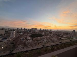 a view of a city at sunset with buildings at Apartment in La Victoria in Lima