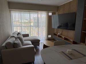 a living room with a couch and a large window at Apartment in La Victoria in Lima