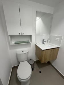 a white bathroom with a toilet and a sink at Apartment in La Victoria in Lima +15 photos