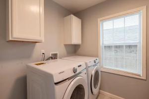 a white washer and dryer in a kitchen with a window at Two Homes - Charming Home and Cozy Bungalow in Tulsa