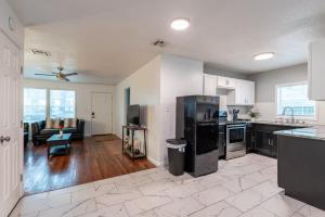 a kitchen with black appliances and a living room at Two Homes - Charming Home and Cozy Bungalow in Tulsa