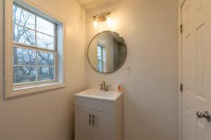 a bathroom with a sink and a mirror at Two Homes - Charming Home and Cozy Bungalow in Tulsa +26 photos