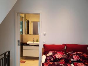 Un dormitorio con una cama y un baño con lavabo. en Seeapartment Wustrau, en Wustrau