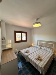 a bedroom with a bed with two slippers on it at El Balcón de Villablancas in La Manga del Mar Menor