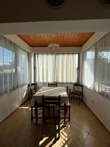 a dining room with a table and chairs and windows at Holiday Home Zenit in Ulcinj