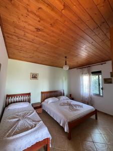 two beds in a bedroom with a wooden ceiling at Holiday Home Zenit in Ulcinj