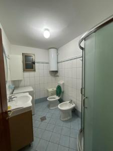 a bathroom with two sinks and two toilets in it at Holiday Home Zenit in Ulcinj +32 photos