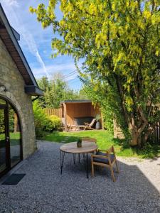 a table and a chair and a table and a tree at La Cachette de Simone in Spa