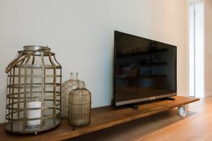 a flat screen tv sitting next to two glass bottles at Palau de la Musica Apartments in Barcelona