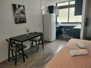 a small kitchen with a table and a refrigerator at Sea loft with a huge bed in Icod de los Vinos
