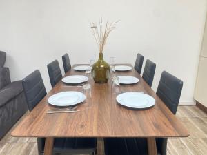 a wooden table with plates and a vase on it at Privates & gemütliches Appartement inklusive Parkplatz in Drensteinfurt