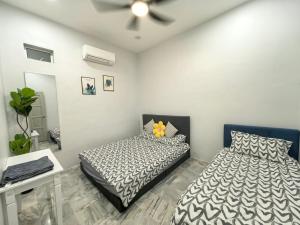 a bedroom with two beds and a ceiling fan at 32 Homestay in Teluk Intan