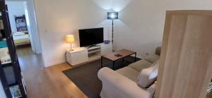 un soggiorno con divano e TV a schermo piatto di Joli appartement 2 chambres avec vue sur le Tage à Algés ad Algés