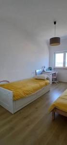 una camera da letto con un grande letto con una coperta gialla di Joli appartement 2 chambres avec vue sur le Tage à Algés ad Algés