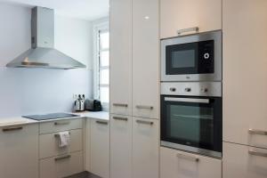 une cuisine avec un micro-ondes et une cuisinière dans l'établissement Palau de la Musica Apartments, à Barcelone 31 autres photos