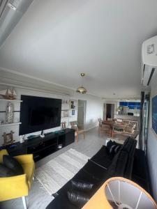 a living room with a couch and a tv at Apartamento em Ubatuba com vista para o mar in Ubatuba