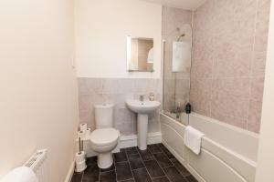 a bathroom with a toilet and a sink and a tub at St Augustines Seaside Retreat in Westgate on Sea +24 photos
