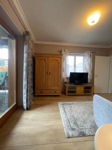 a living room with a tv and a large window at Edelweiss Chalet in Uttendorf