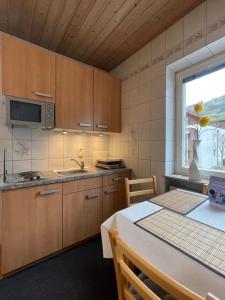 a kitchen with wooden cabinets and a table and a window at Edelweiss Chalet in Uttendorf