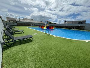 a large swimming pool with a playground in a yard at Northcott 68, Bude in Poughill