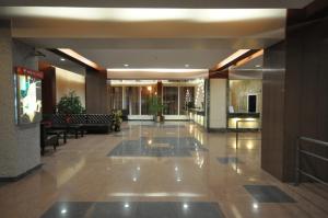 a lobby of a hotel with tables and chairs at Hotel Šiauliai in Šiauliai