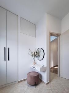 a white room with a stool and a mirror at Marisa in Ierapetra +40 photos