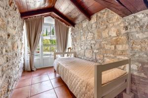 a bedroom with a bed in a stone wall at Boutique B&B Stancija 1904 Adults only in Svetvinčenat