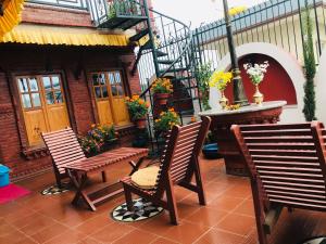 un patio con due sedie e una scala con fiori di Blue Mountain Home Stay a Kathmandu