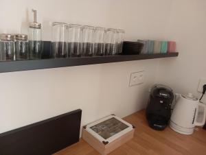 a kitchen with a counter with glasses on a shelf at Au bord de la kirneck in Barr
