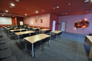 a classroom with tables and chairs in a room at Hotel Šiauliai in Šiauliai