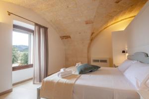 a bedroom with a large bed and a window at Masseria Galleppa by Apulia Hospitality in Monopoli