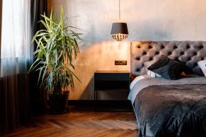 a bedroom with a bed and a table with a plant at Black Princess in Cēsis